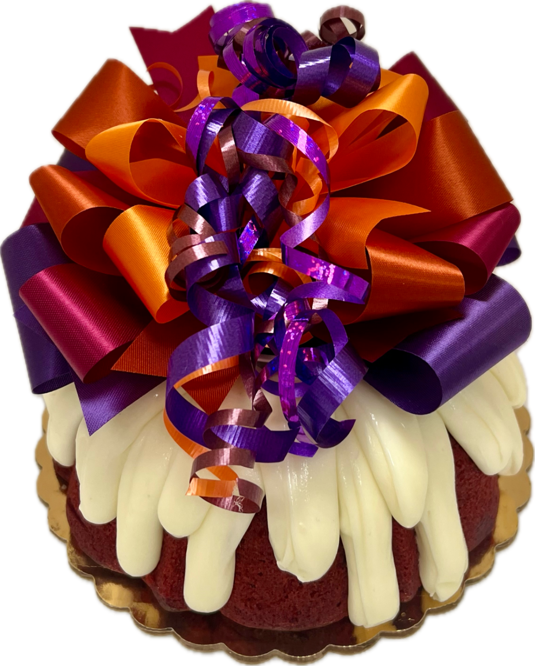 A cake decorated with a handcrafted bow featuring festive fall colors, in this case, purple and orange, on a red velvet Bundt cake.